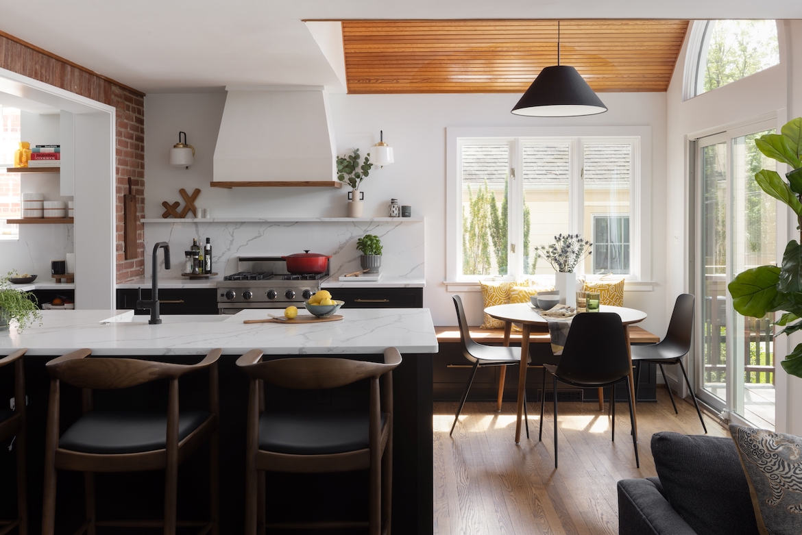 Open concept kitchen and dining room space with a black island and white countertop